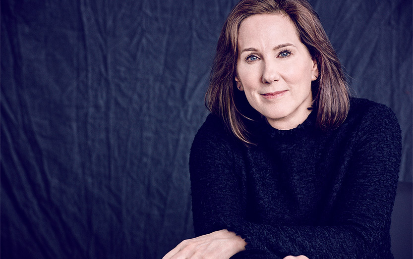 Kathleen Kennedy's headshot in front of a cloth navy backdrop